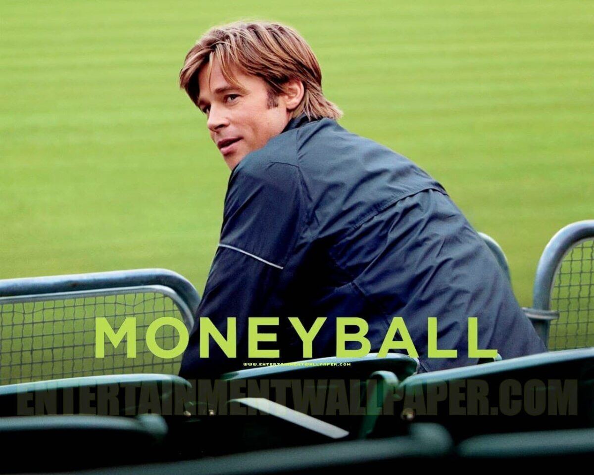 Capa do filme Moneyball, um homem está sentado na arquibancada de um campo de futebol